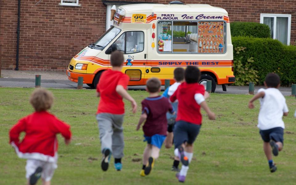 Children running to the sound of the visiting ice-cream van - ALAMY