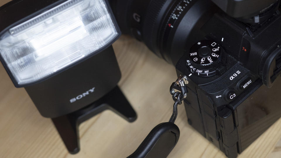 Sony A9 III with wireless radio commander alongside the Sony HVL 46RM flash on a wooden table