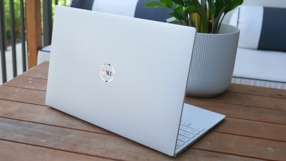  Dell XPS 13 OLED on an outdoor table with the logo on the lid facing the camera. 