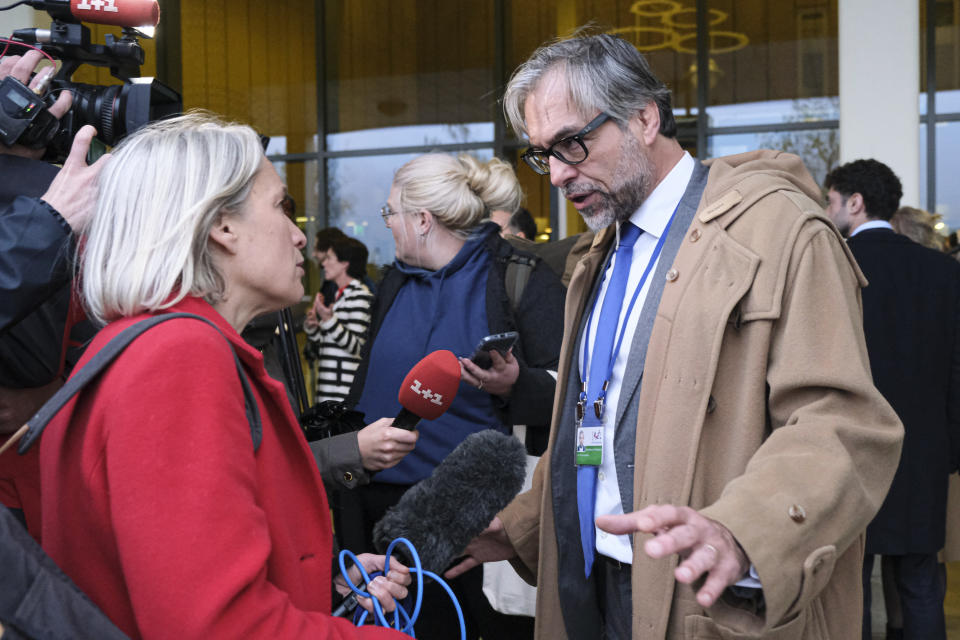 Peter Langstraat, right, a lawyer for the victims in the downing of Malaysia Airlines flight 17 trial speaks to media after the court's verdict at Schiphol airport, near Amsterdam, Netherlands, Thursday, Nov. 17, 2022. A Dutch court has convicted two Russians and a Ukrainian of the murders of 298 people who died in the 2014 downing of Malaysia Airlines flight MH17 over Ukraine. One Russian was acquitted for lack of evidence.(AP Photo/Patrick Post)