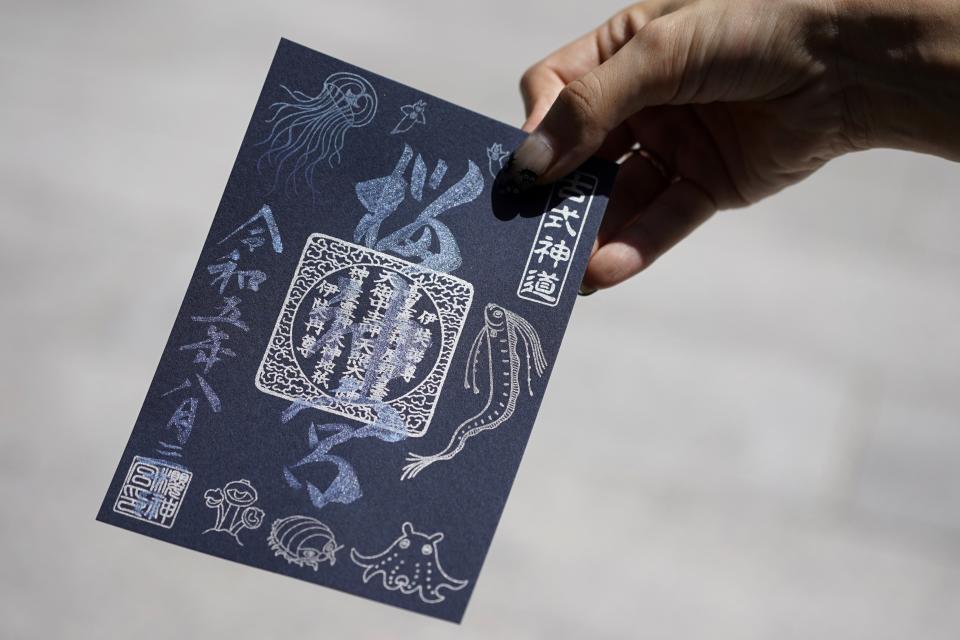 Momo Nomura, a graphic artist and entrepreneur, shows a newly collected Goshuin, a seal stamp certifying her visit that comes with elegant calligraphy and the season’s drawings, at Sakura Jingu shrine in Tokyo on Aug. 30, 2023. “Because of the Goshuin, shrines have become closer to me, but I don’t consider this a religious activity,” Nomura said. (AP Photo/Eugene Hoshiko)
