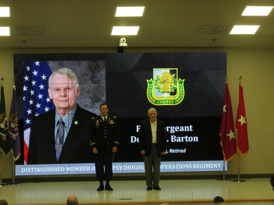 Retired 1st Sgt. Donald Barton is welcomed by Lt. Col. Jeffrey Souther as a distinguished member of the psychological operations regiment during a Nov. 4, 2021, ceremony at Fort Bragg.