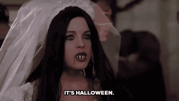 Woman dressed as a vampire bride with faux blood on lips, captioned "IT'S HALLOWEEN."