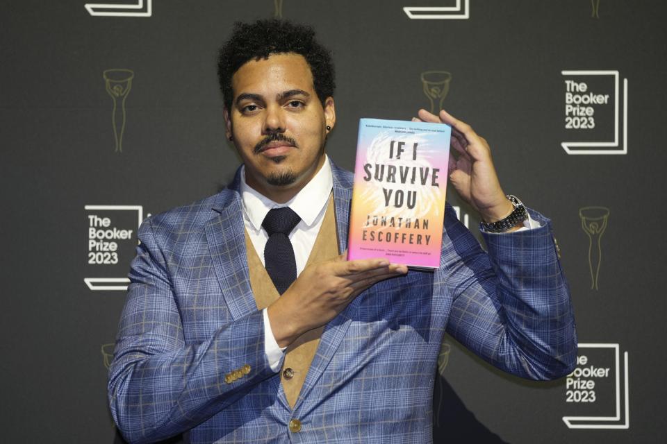 American author Jonathan Escoffery poses with his book "If I Survive You" during a photocall with the six shortlisted authors for the Booker Prize 2023, in London, Thursday, Nov. 23, 2023 ahead of the award ceremony on Nov. 26 in London. (AP Photo/Kin Cheung)