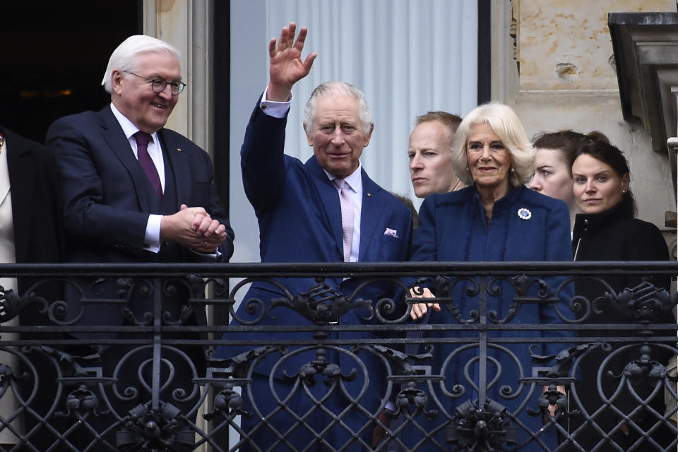 German President Frank-Walter Steinmeier, left, watches as Britain's King Charles III, with Camilla, the Queen Consort, waves from a balcony of the city hall in Hamburg, Germany, Friday, March 31, 2023. King Charles III arrived Wednesday for a three-day official visit to Germany. (AP Photo/Gregor Fischer)