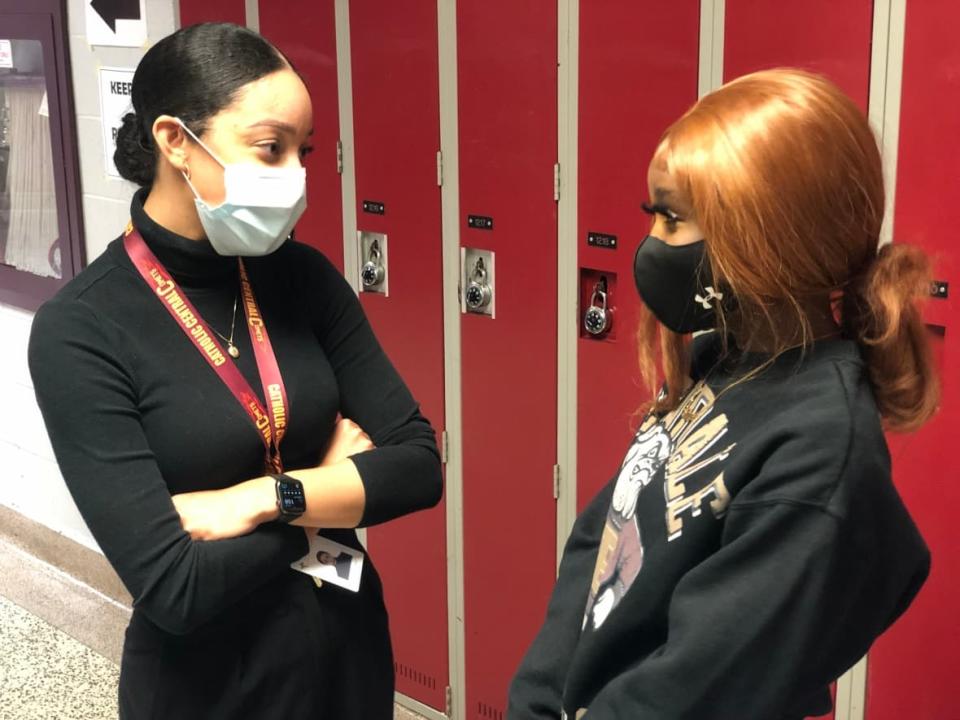 Graduation coach Sydnie Moore chatting with Grade 12 student Sarah Alimasi in the hallway at Catholic Central High School. (Jacob Barker/CBC - image credit)