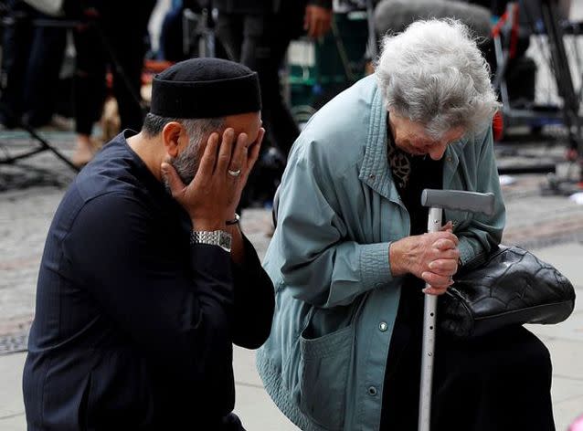 Sadiq Patel helped 93-year-old Renee Rachel Black offer their prayers to the victims. Source: Reuters