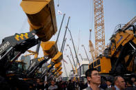 FILE PHOTO: People visit heavy machinery at Bauma China, the International Trade Fair for Construction Machinery in Shanghai, China November 27, 2018. REUTERS/Aly Song