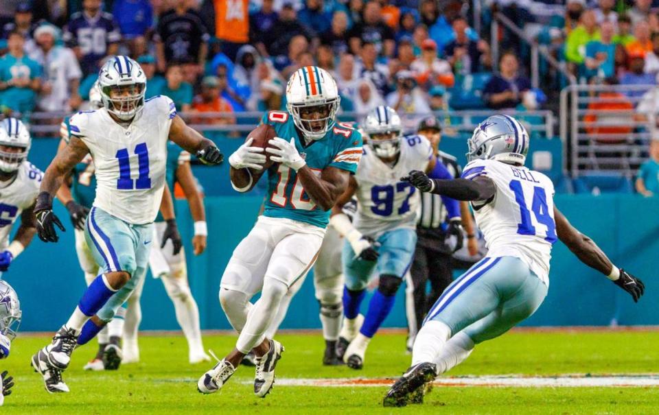 Miami Dolphins wide receiver Tyreek Hill (10) catches a pass against the defense of Dallas Cowboys linebacker Micah Parsons (11) and Cowboys safety Markquese Bell (14) during second quarter of an NFL football game at Hard Rock Stadium on Sunday, Dec. 24, 2023 in Miami Gardens, Fl.