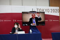 International Olympic Committee (IOC) president Thomas Bach (on-screen) and Tokyo 2020 president Seiko Hashimoto, left, wave at the beginning of the five-party meeting in Tokyo, Thursday, July 8, 2021. (Behrouz Mehri/Pool Photo via AP)