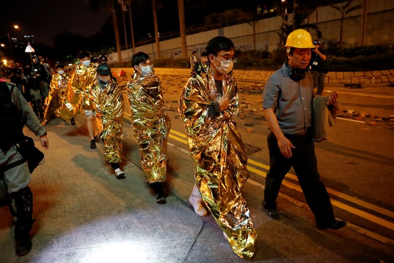 Protesters walk before being taken to hospitals, at Hong Kong Polytechnic University (PolyU) campus, in Hong Kong