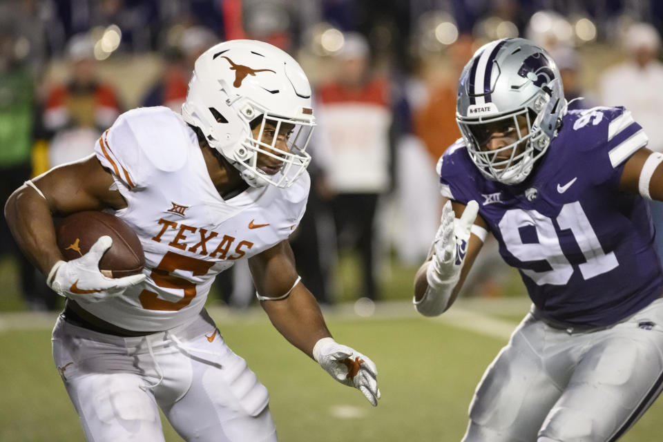 FILE - Texas running back Bijan Robinson (5) is pursued by Kansas State defensive end Felix Anudike-Uzomah (91) during the second half of an NCAA college football game on Nov. 5, 2022, in Manhattan, Kan. In an age of “opt-outs” in college football, the best NFL prospects for Alabama and Kansas State are opting in at the Sugar Bowl, on Saturday, Dec. 30, 2022, including Anudike-Uzomah. (AP Photo/Reed Hoffmann, File)