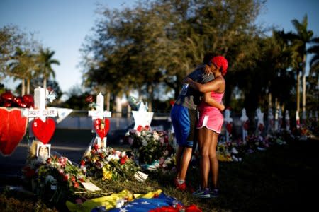 Adin Chistian (16), student of the Marjory Stoneman Douglas High School, embraces his mother Denyse, next to the crosses and Stars of David placed in front of the fence of the school to commemorate the victims of a shooting, in Parkland, Florida. 


REUTERS/Carlos Garcia Rawlins