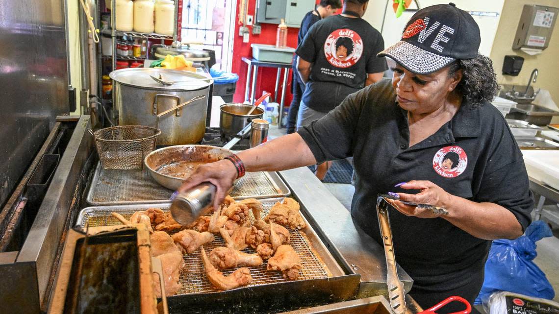 Gloria Hall seasons fried chicken in the kitchen at Doll’s Kitchen in Fresnowhere everyone working there is family.