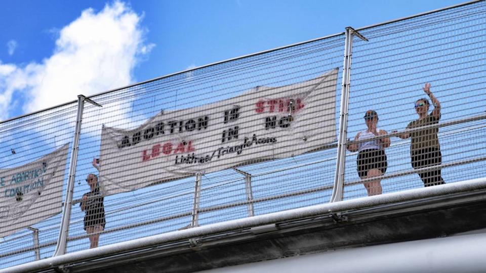 Volunteers with the Triangle Abortion Access Coalition, wave to cars passing under the American Tobacco Trail Bridge over I-40 in Durham, N.C. on June 24, 2022 the afternoon that the Supreme Court decision overturning Roe v. Wade was handed down. The volunteers are occupying the bridge throughout the day. “We’re sharing the knowledge and news that abortion is still legal in this state. And we will fight to keep it legal,” one advocate said.