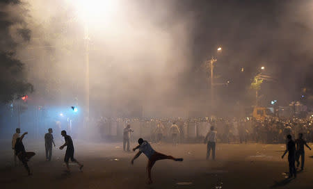 Demonstrators who had gathered in a show of support for gunmen holding several hostages in a police station, clash with riot police in Yerevan, Armenia, July 20, 2016. REUTERS/Vahram Baghdasaryan/Photolure
