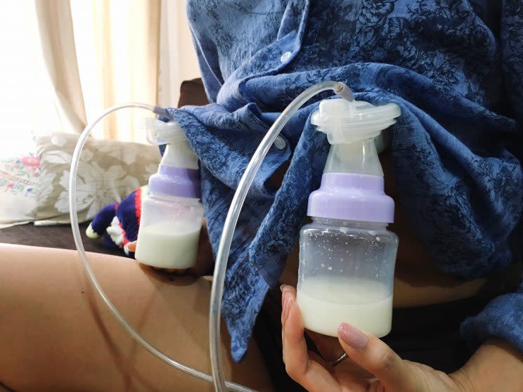 A woman uses a breast pump.