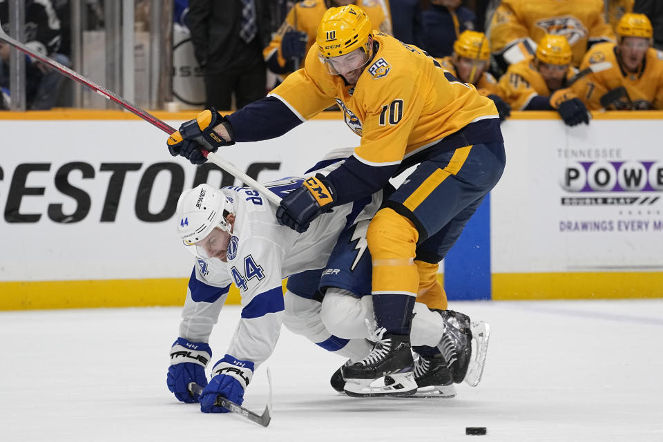 Nashville Predators center Colton Sissons (10) pushes Tampa Bay Lightning defenseman Calvin de Haan (44) to the ice during the second period of an NHL hockey game Thursday, Dec. 7, 2023 in Nashville, Tenn. (AP Photo/George Walker IV)