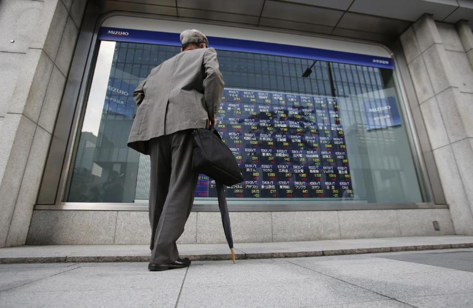 A man watches an electronic stock indicator of a securities firm in Tokyo, Tuesday, May 13, 2014. Asian stock markets rose after Wall Street indexes hit record highs, with Japan's Nikkei 225 leading gains as the yen weakened. The Nikkei ended up 275.92 points at 14,425.44 on Tuesday. (AP Photo/Shizuo Kambayashi)