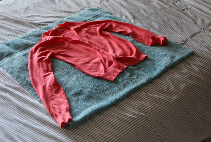 Sweater, which was hand washed, laying flat to dry on a towel.