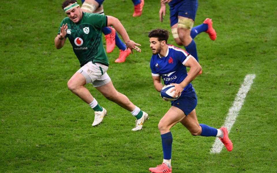 France's fly-half Romain Ntamack (R) runs with the ball during the Six Nations rugby union tournament match between France and Ireland at the stade de France, - AFP