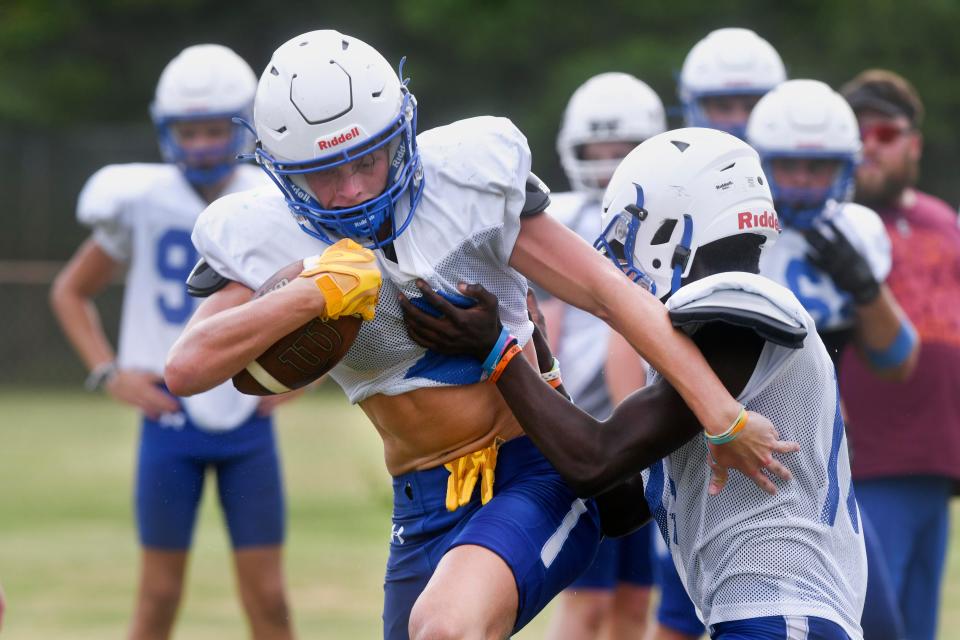 Destin High School's Price Bowen runs the ball during a drill last week as the school's first football team prepares for the upcoming season. 