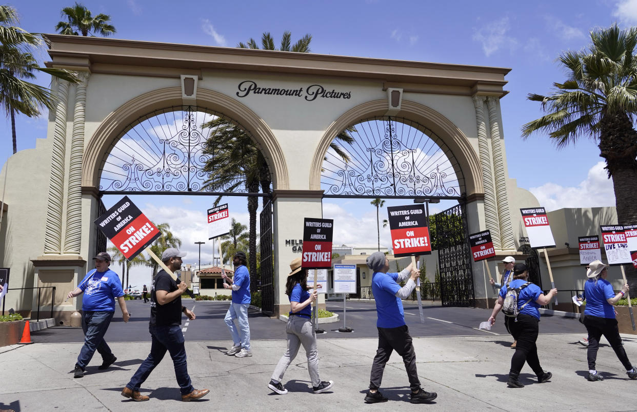 Members of the The Writers Guild of America West picket at an entrance to Paramount Pictures, Tuesday, May 2, 2023, in Los Angeles. The first Hollywood strike in 15 years began Tuesday as the economic pressures of the streaming era prompted unionized TV and film writers to picket for better pay outside major studios, a work stoppage that already is leading most late-night shows to air reruns. (AP Photo/Chris Pizzello)