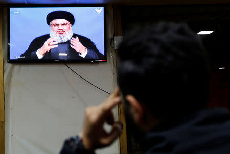 A man watches Lebanon's Hezbollah leader Sayyed Hassan Nasrallah as he speaks on television in Beirut, Lebanon November 20, 2017.REUTERS/ Jamal Saidi