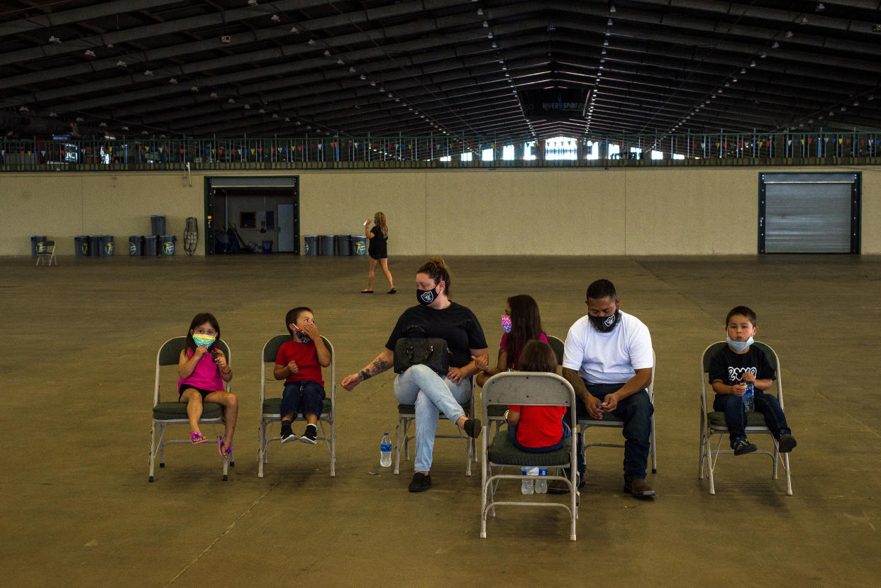 Una pareja espera con sus hijos a que les ayuden a presentar solicitudes de seguro por desempleo durante un evento presencial organizado por la Comisión para la Seguridad del Empleo de Oklahoma, en Tulsa, Oklahoma, el 24 de julio de 2020. (Joseph Rushmore/The New York Times)