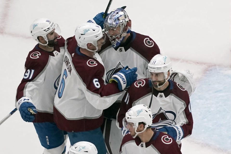 Colorado Avalanche goaltender Darcy Kuemper celebrates with teammates Nazem Kadri (91), Erik Johnson (6) and Andrew Cogliano (11) following a 5-2 victory over the St. Louis Blues in Game 3 of an NHL hockey Stanley Cup second-round playoff series Saturday, May 21, 2022, in St. Louis. (AP Photo/Jeff Roberson)