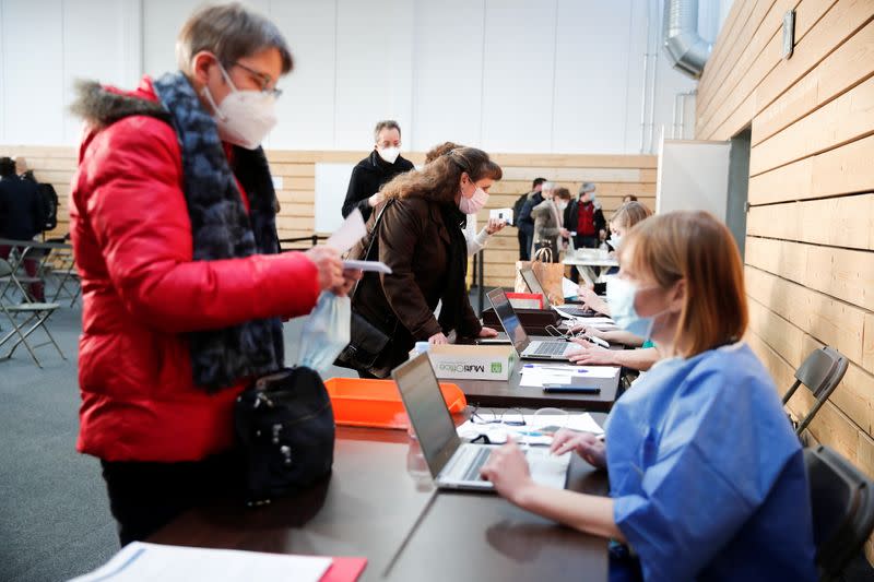 Trabajadores de la salud registrándose para recibir la vacuna COVID-19 de Pfizer-BioNTech en un centro de vacunación dentro de un gimnasio en Taverny cerca de París, Francia, el 9 de enero de 2021