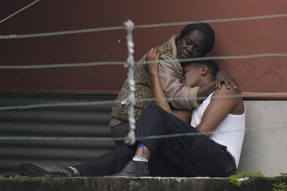 Residents embrace after fatal mudslides in Petropolis, Brazil, early Wednesday, Feb. 16, 2022. Extremely heavy rains set off mudslides and floods in a mountainous region of Rio de Janeiro state, killing multiple people, authorities reported. (AP Photo/Silvia Izquierdo)