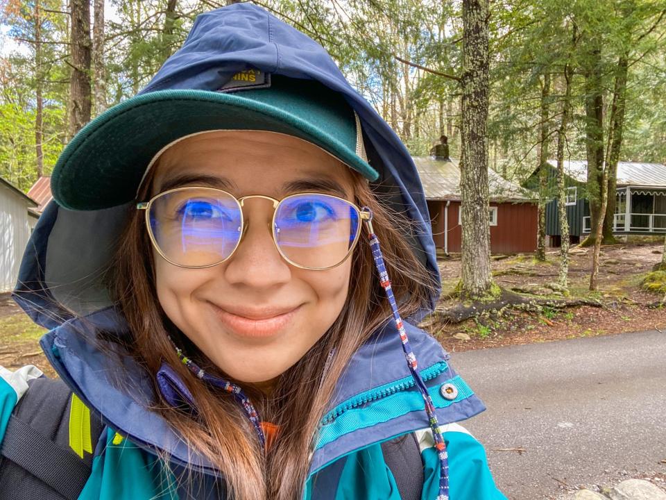 The author stands in front of a preserved village in the Great Smoky Mountains.