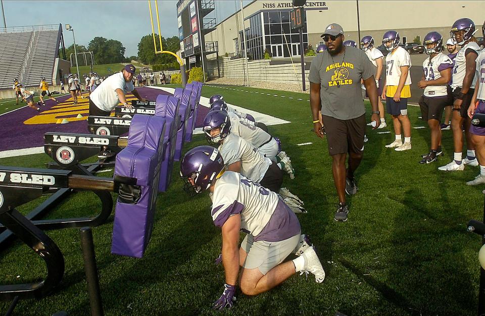 Ashland University assistant coach Reggie Gamble watches his players go through a drill during the first practice session of training camp Thursday, Aug. 11, 2022.