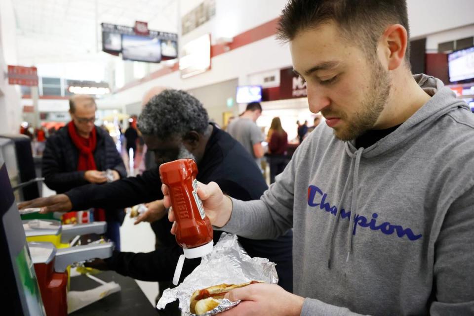 The State reporter Jordan Kaye squirts ketchup on a hot dog during Friday’s South Carolina basketball game.