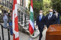 In this photo released by Lebanon's official government photographer Dalati Nohra, Lebanese Foreign Minister Charbel Wehbe, right, meets with Canadian Foreign Minister François-Philippe Champagne outside the Lebanese foreign ministry damaged by the Aug. 4 deadly blast in the port of Beirut that killed scores and wounded thousands in Beirut, Lebanon, Thursday, Aug. 27, 2020. (Dalati Nohra via AP)