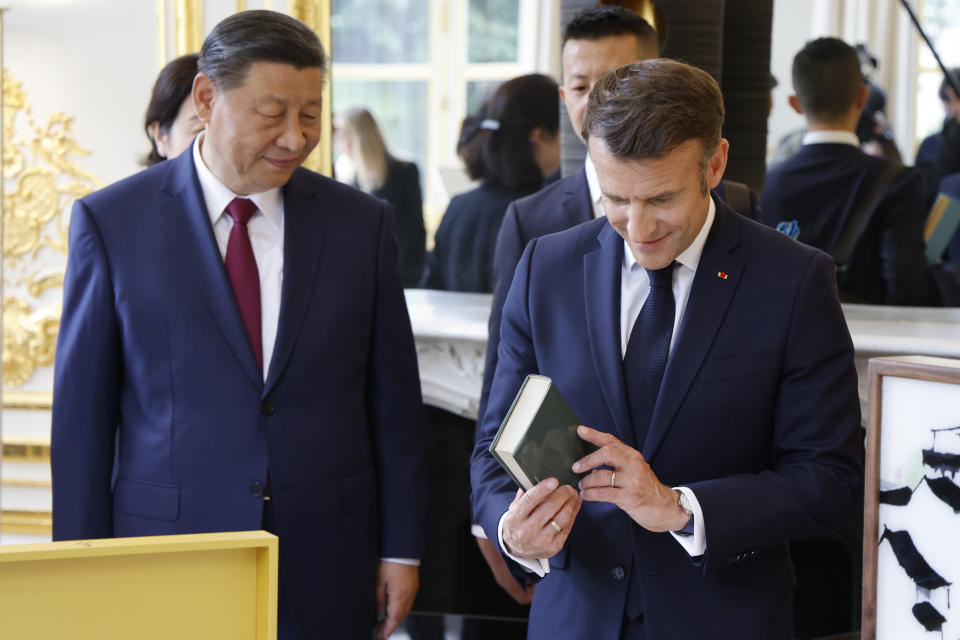 China's President Xi Jinping presents books by French authors produced in China to French President Emmanuel Macron, right, during a gifts exchange at the Elysee Palace in Paris, Monday, May 6, 2024. China's President Xi Jinping is in France for a two-day state visit that is expected to focus both on trade disputes and diplomatic efforts to convince Beijing to use its influence to move Russia toward ending the war in Ukraine. (Ludovic Marin, Pool via AP)