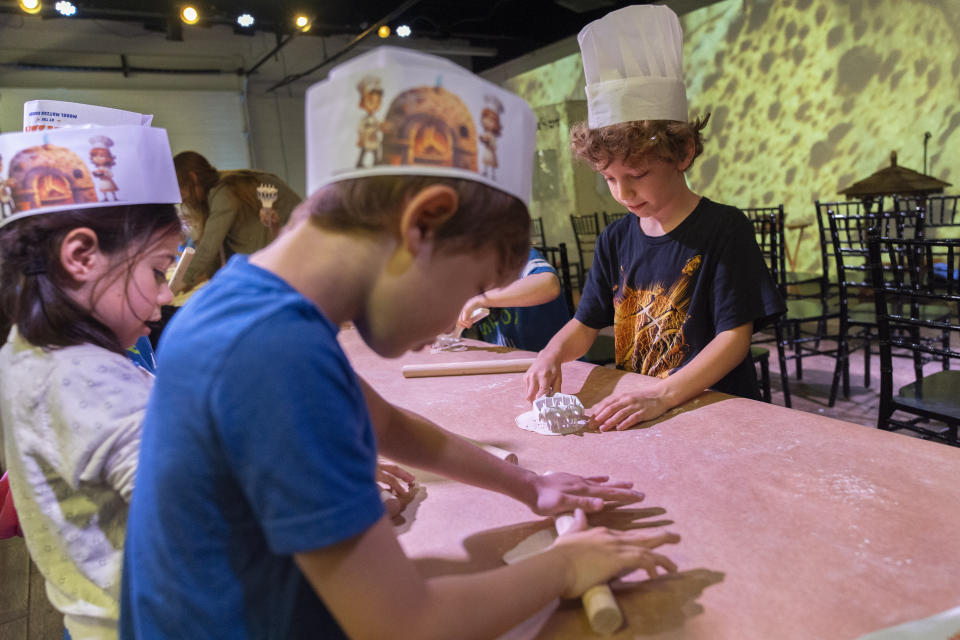 First graders from Milton Gottesman Jewish Day School of the Nation's Capital, make matzah during a "Matzah Factory" field trip at the JCrafts Center for Jewish Life and Tradition in Rockville, Md., Thursday, April 18, 2024, ahead of the Passover holiday which begins next Monday evening. To be kosher for Passover the dough has to be prepared and cooked all within 18 minutes and not allowed to rise. (AP Photo/Jacquelyn Martin)