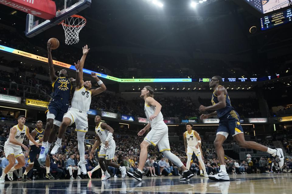 Indiana Pacers' Aaron Nesmith (23) shoots against Utah Jazz's Talen Horton-Tucker (5) during the first half of an NBA basketball game, Wednesday, Nov. 8, 2023, in Indianapolis. (AP Photo/Darron Cummings)