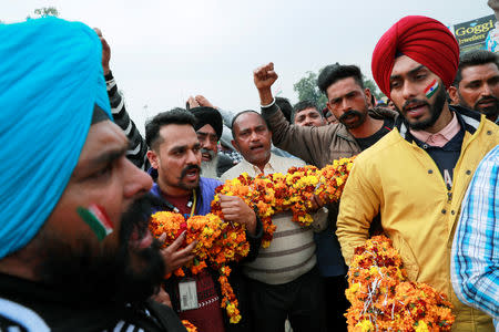 People hold a garland as they shout patriotic slogans before the arrival of the Indian Air Force pilot, who was captured by Pakistan on Wednesday, near Wagah border, on the outskirts of Amritsar, March 1, 2019. REUTERS/Danish Siddiqui