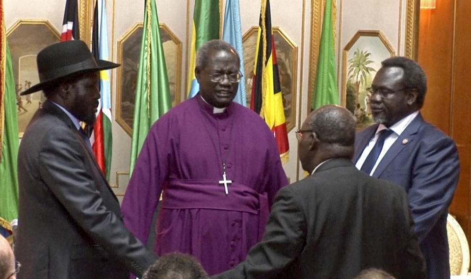 In this Friday, May 9, 2014 image made from video, South Sudan's President Salva Kiir, left, and rebel leader Riek Machar, right, shake hands and pray before signing an agreement of the cease-fire of the conflict in South Sudan in Addis Ababa, Ethiopia. The South Sudan's president has reached a cease-fire agreement with the rebel leader, an African regional bloc said Friday, after a vicious cycle of revenge killings drew international alarm. (AP Photo/AP Video)