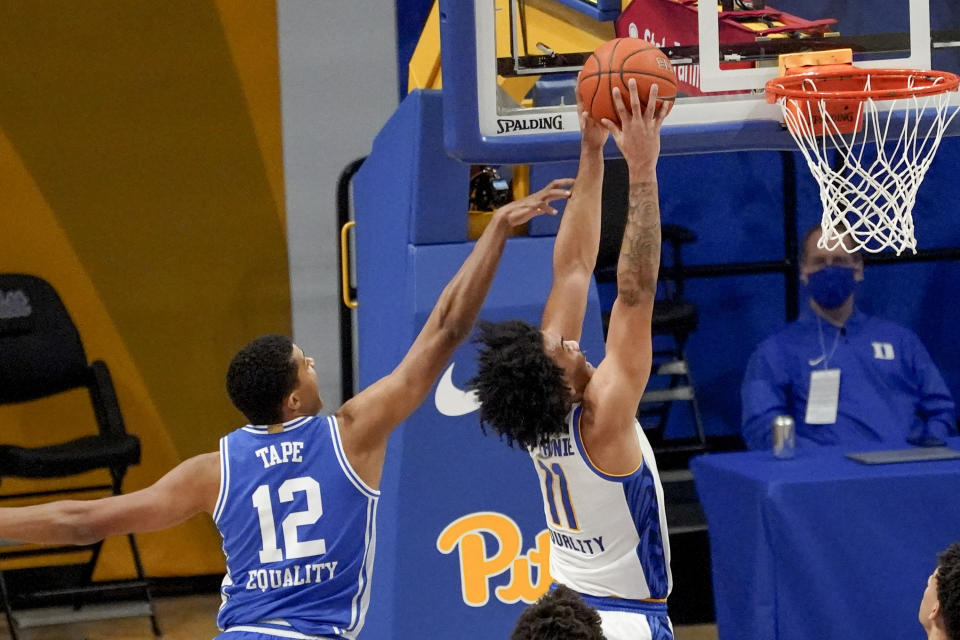 Pittsburgh's Justin Champagnie (11) dunks after getting by Duke's Patrick Tape (12) during the first half of an NCAA college basketball game, Tuesday, Jan. 19, 2021, in Pittsburgh. (AP Photo/Keith Srakocic)