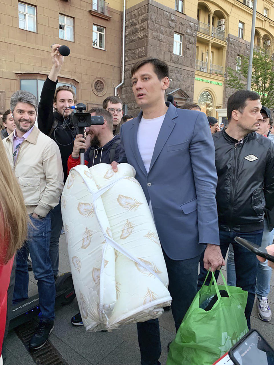 Dmitry Gudkov, center, a former Russian lawmaker who has aspired to run again for a parliament seat, is surrounded by people after being released in case of an expiration of 48 hours of detention in Moscow, Russia, Thursday, June 3, 2021. Police have released a well-known Russian opposition politician from custody after holding him for two days. Gudkov was detained by police at his country house on Tuesday in connection with an investigation into money owed to the city for rental of an office space. Gudkov's attorney, Mikhail Biryukov, said it was not clear whether the Thursday release of Gudkov meant the investigation was still active. (AP Photo/Vladimir Kondrashov)