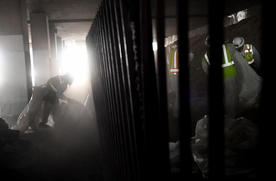 Crews clear out a homeless encampment under the 405 Freeway in Inglewood.