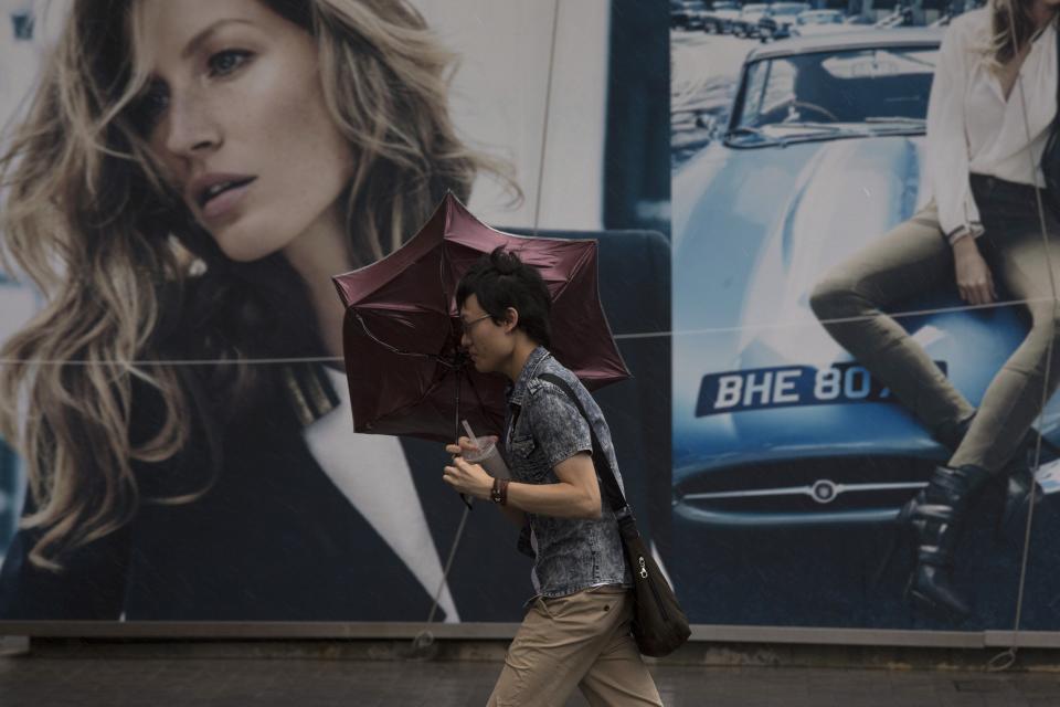 A man braves gusty winds outside a shopping mall at Tsim Sha Tsui shopping district during Typhoon Usagi in Hong Kong September 22, 2013. Hong Kong was bracing on Sunday for this year's most powerful typhoon, with government meteorologists warning of severe flooding created by a double whammy of powerful winds and exceptionally high tides.REUTERS/Tyrone Siu (CHINA - Tags: ENVIRONMENT DISASTER)