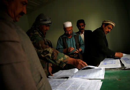 Workers sign attendance sheets as they arrive for work at the Jabal Saraj cement factory in Jabal Saraj, north of Kabul, Afghanistan April 19, 2016. REUTERS/Ahmad Masood