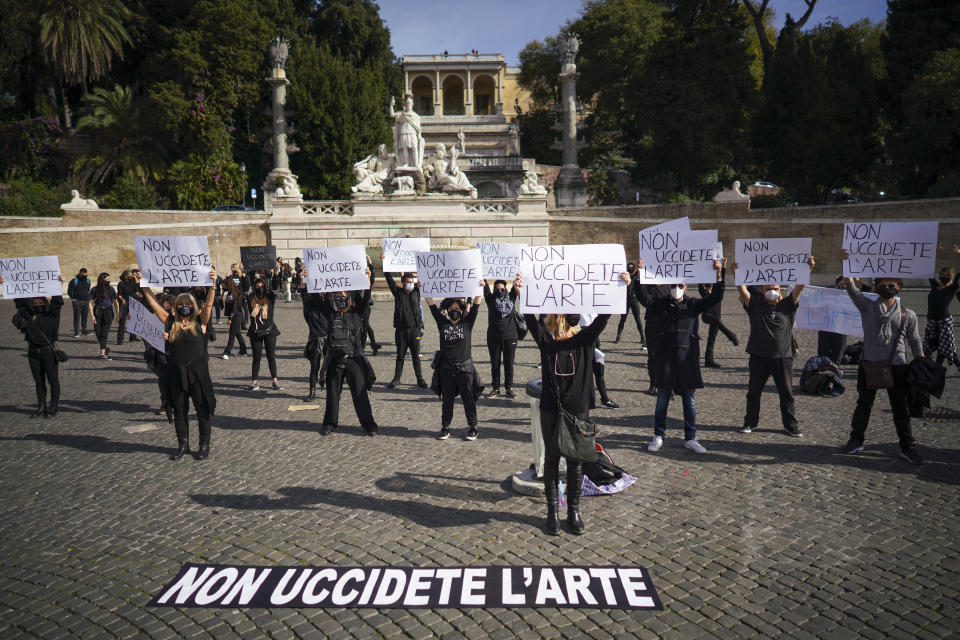 Dancers and theaters workers hold banners reading in Italian "don't kill art" as they stage a protest against the government restriction measures to curb the spread of COVID-19, closing gyms, cinemas and movie theaters, in Rome, Thursday, Oct. 29, 2020. (AP Photo/Andrew Medichini)