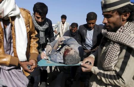 People carry the body of a man they uncovered from under the rubble of a house destroyed by an air strike near Sanaa Airport March 26, 2015. REUTERS/Khaled Abdullah