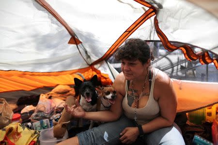 Tashea Martinez, 38, who said she had been homeless since she was a teenager, sits in her tent with her dogs in Los Angeles, California, U.S. April 13, 2018. Picture taken April 13, 2018. REUTERS/Lucy Nicholson