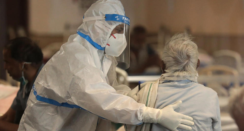 Medical worker in PPE with patient.